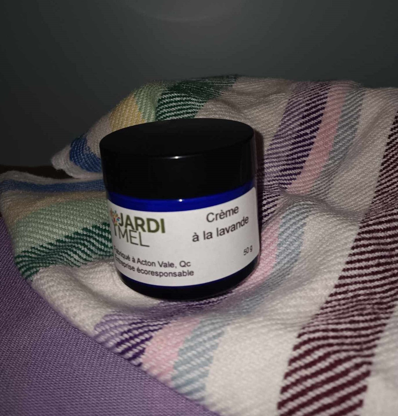 Crème à la lavande naturelle dans un pot en verre de 50g, formulée avec des ingrédients biologiques tels que l'huile de tournesol, l'huile de jojoba et le beurre de karité, pour hydrater, nourrir et protéger la peau tout en profitant des bienfaits apaisants de la lavande.