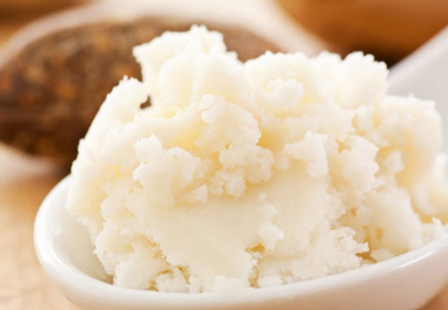 L'image montre du beurre de karité bio, une substance crémeuse et blanche, connue pour ses propriétés hydratantes et nourrissantes.